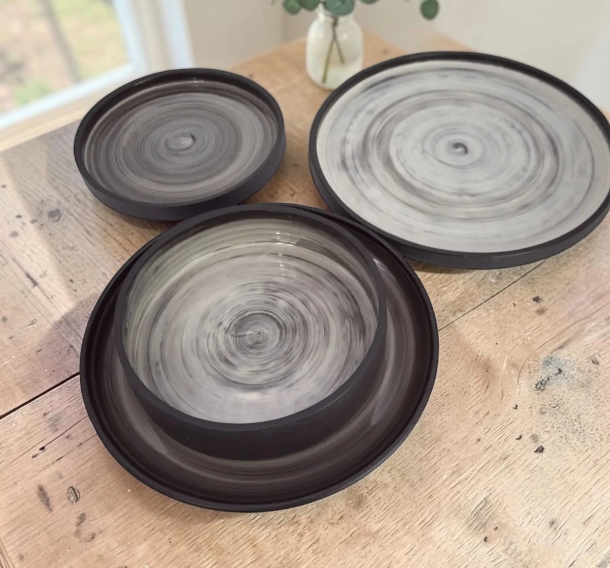 Großer Teller, kleiner Teller und Buddha Bowl der Linie minimal auf einem Holztisch